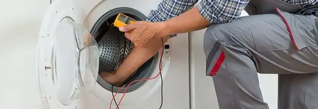 Dryer repair technician inspecting and repairing a clothes dryer in Santa Ana, CA