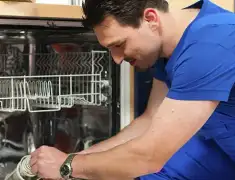 Dishwasher repair technician inspecting and servicing an open dishwasher in Santa Ana, CA