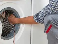 Dryer repair technician diagnosing and servicing a clothes dryer in Santa Ana, CA