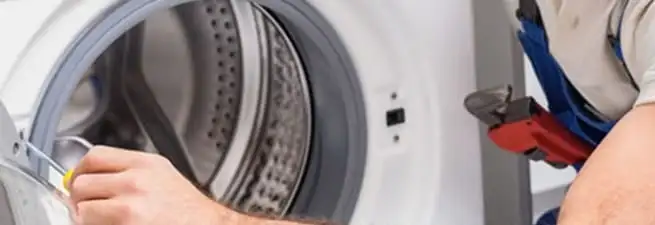 Appliance technician repairing a clothes dryer drum and internal parts in Santa Ana, CA