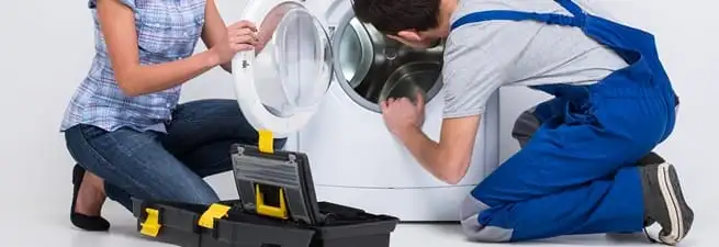 Washer repair technician inspecting a front-load washing machine with tools in Santa Ana, CA