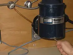 Garbage disposal repair technician tightening the mounting ring under a sink in Santa Ana, CA
