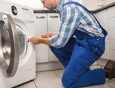 Washing machine repair technician servicing a front-load washer in Santa Ana, CA