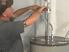 Water heater repair technician tightening supply line connections in Santa Ana, CA